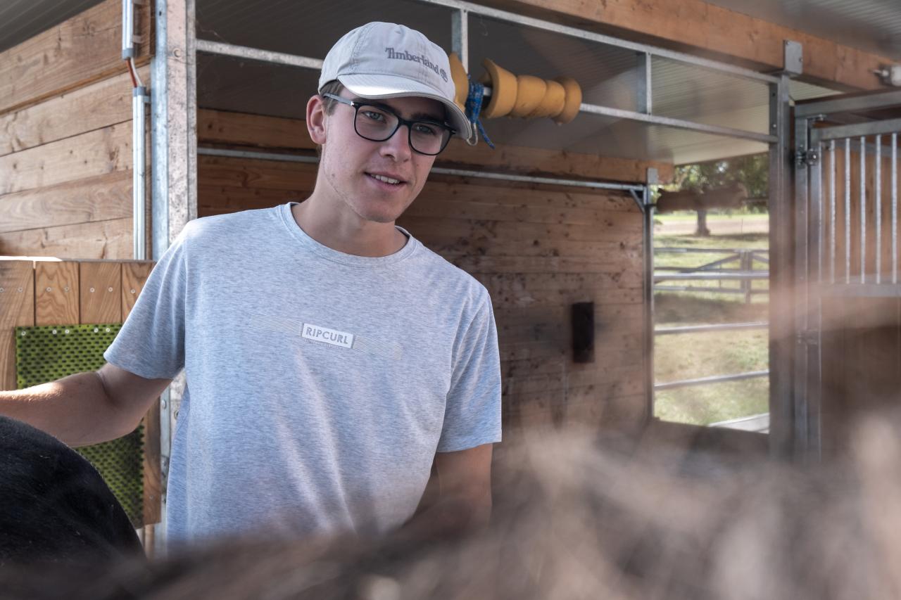 Mann mit Pferd vor dem Stall