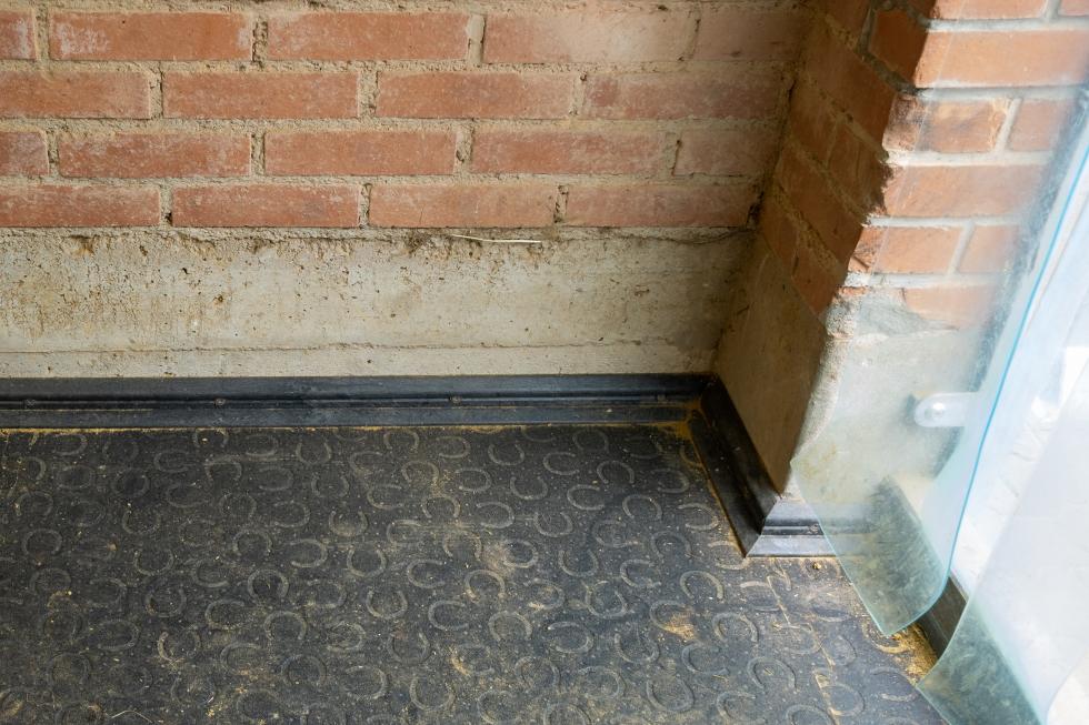 Der Querschnitt einer Gummimatte an einer Wand endend mit einem sitzbankförmigen Winkel abschliessend aufliegend