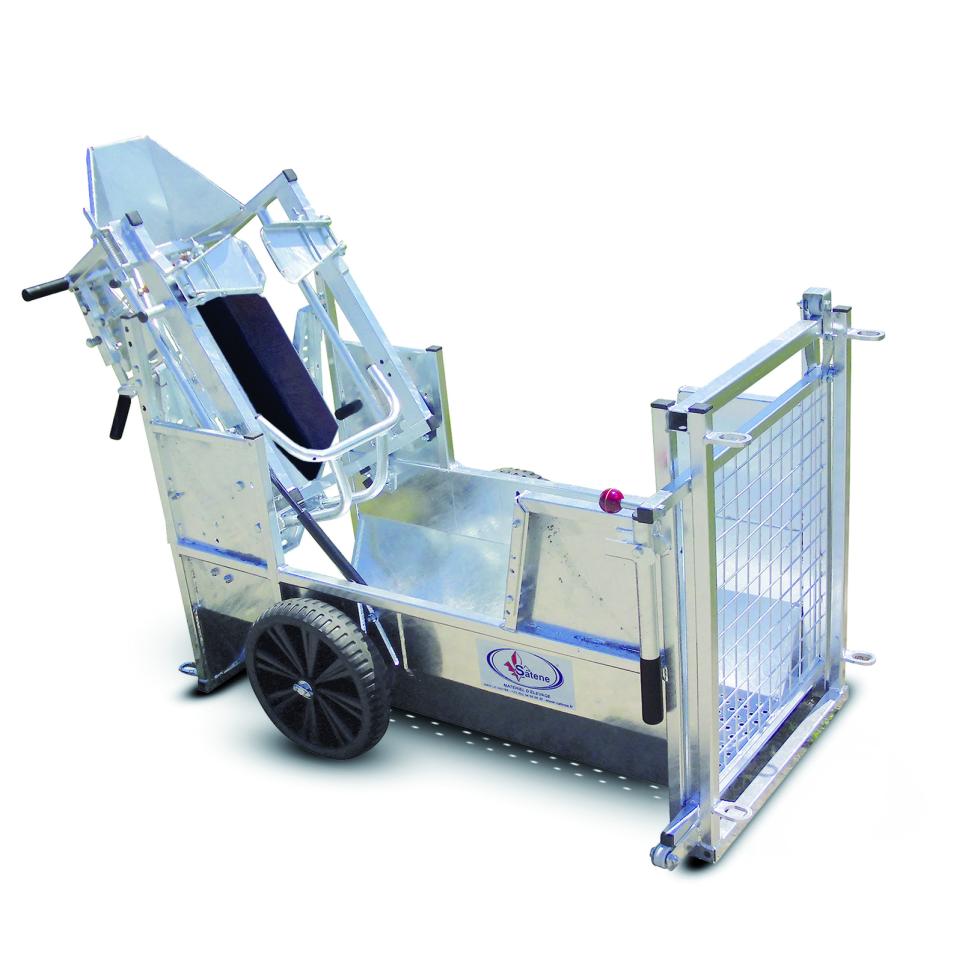 Ein Behandlungs- und Einfangstandstand mit Liegegitter und Schwenkachse, vorne zwei feste schwarze Räder, auf der Hinterseite ein schwarzes Brett