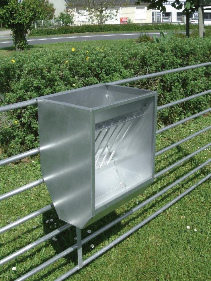 Ein Behandlungs- und Einfangstandstand mit Liegegitter und Schwenkachse, vorne zwei feste schwarze Räder, auf der Hinterseite ein schwarzes Brett, Schaf eingespannt umgedreht, wessen Klauen von einer Person geschnitten werden