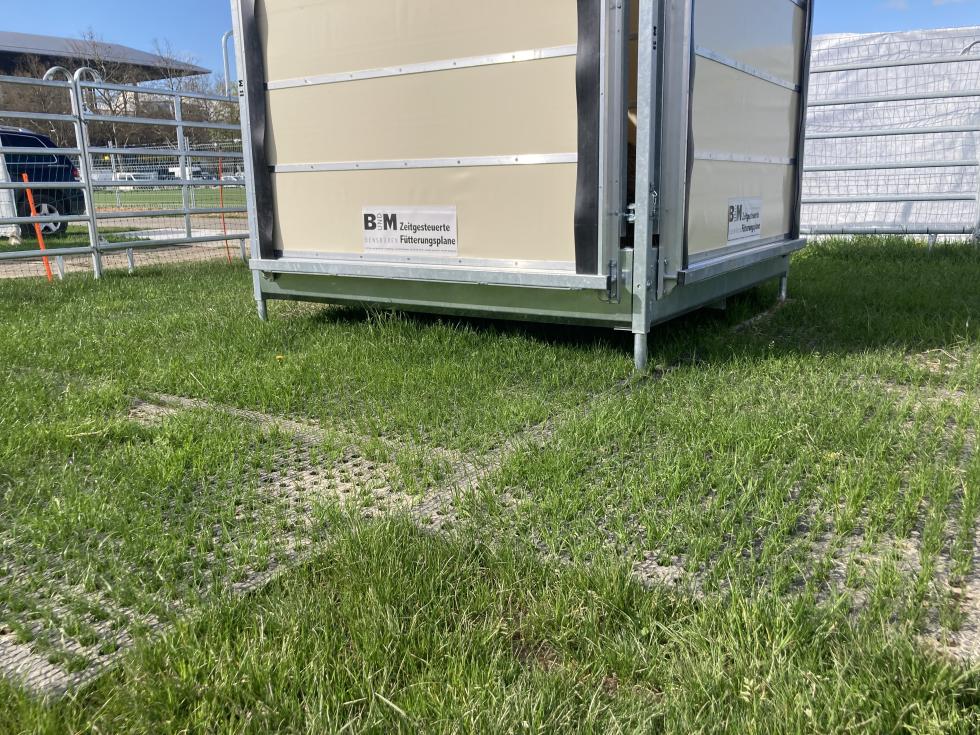 Zwei separate, schwarze Gummimatten nebeneinandergelegt, mit Kabelbindern verbunden, regelmässig angeordneten Löchern, sowie dreckigen Fussabdrücken zentral oben im Bild, Draufsicht