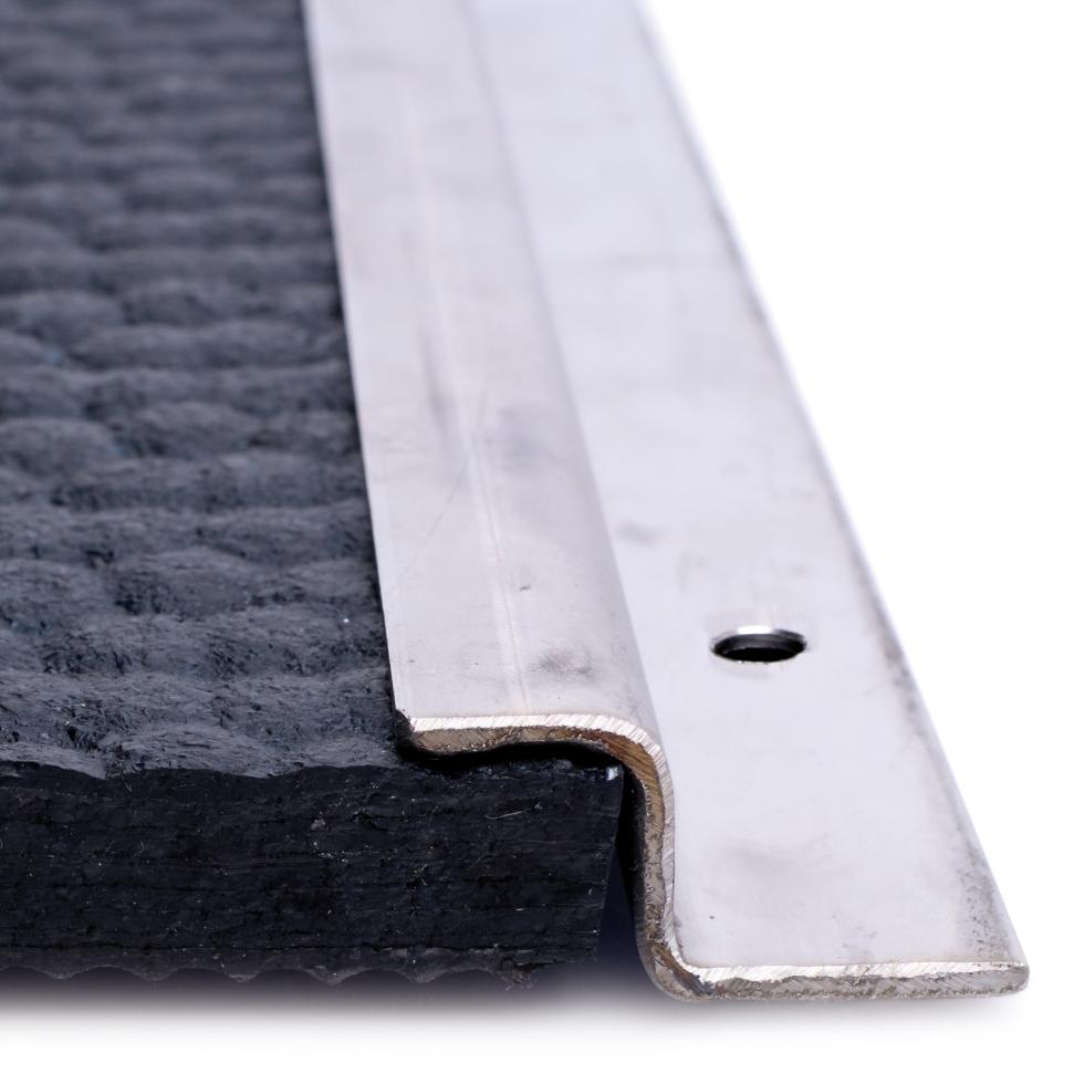 Ein Gummimattenweg, endend mit einem z-förmigen Winkel, welcher auf der Gummimatte aufliegt, im rechten Winkel senkrecht der Seite hinunterfolgt und anschliessend wieder durch einen 90° Winkel waagere